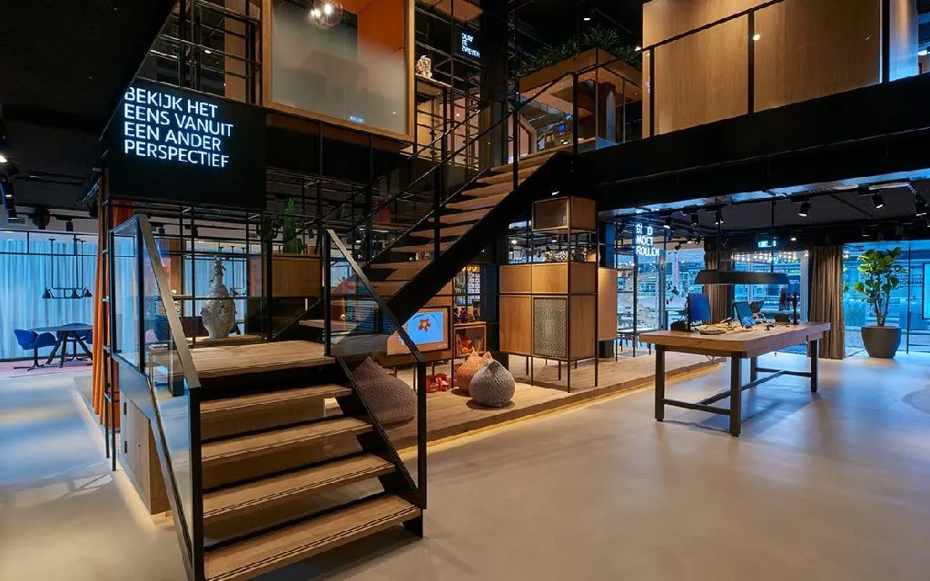 Black steel stair with timber treads beside a neon wall message