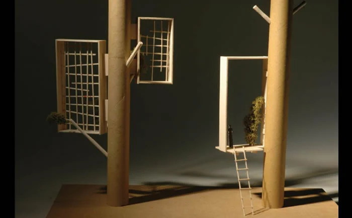 Card sketch model of two posts carrying open frames, one reached by a ladder, with a small figure for scale