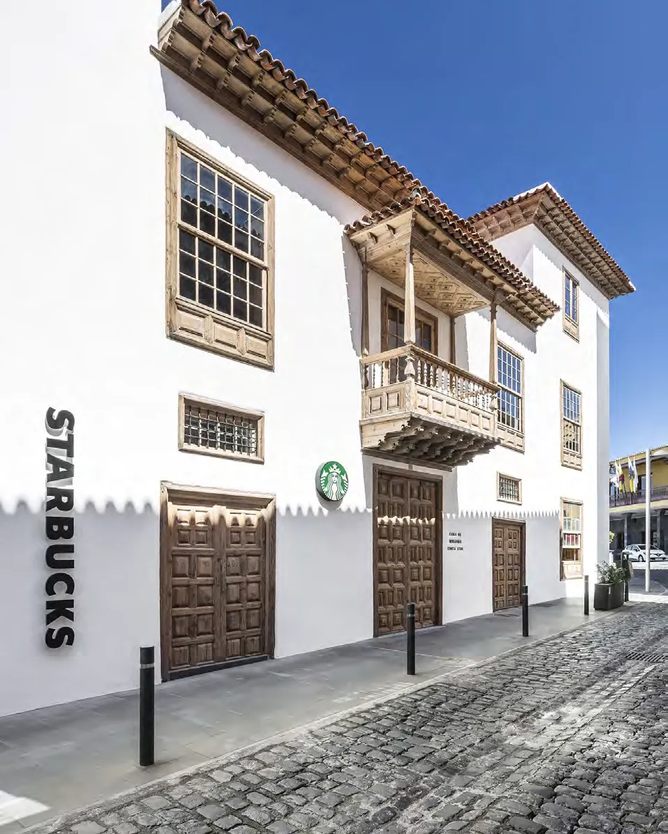 White Canarian facade with timber balconies on a cobbled street