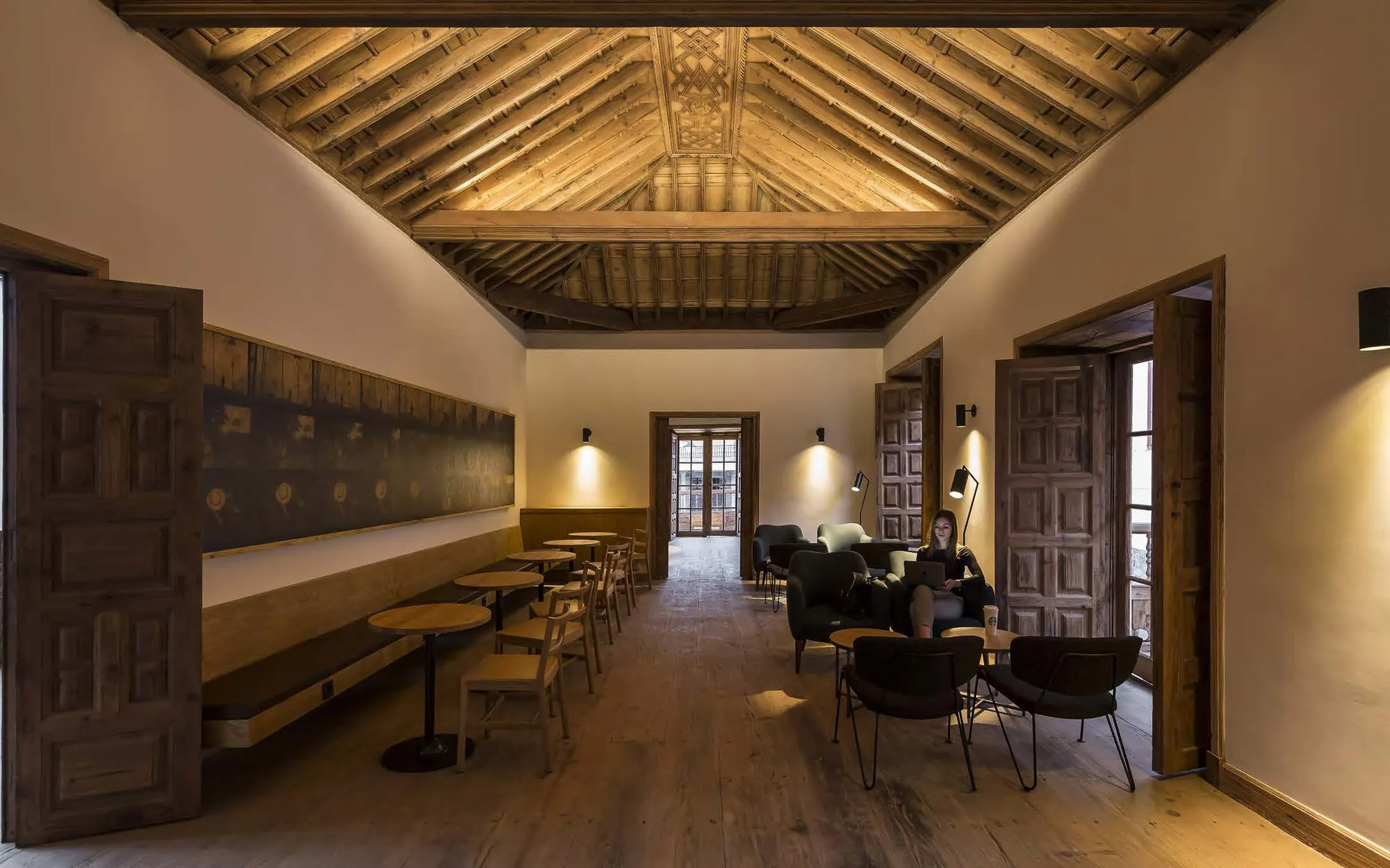 Long hall with a coffered timber ceiling and seating along the walls