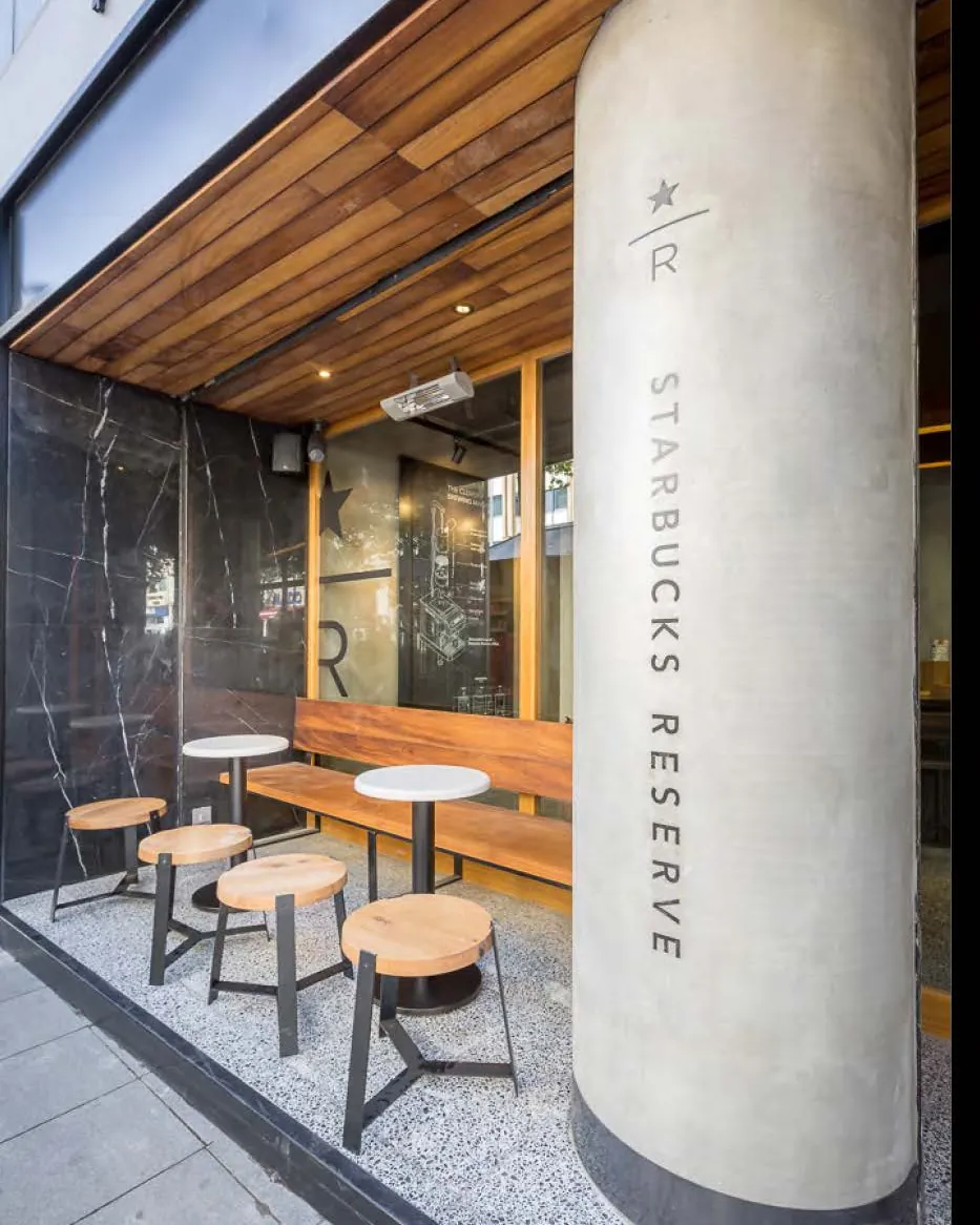 Concrete column engraved with Starbucks Reserve beside outdoor seating